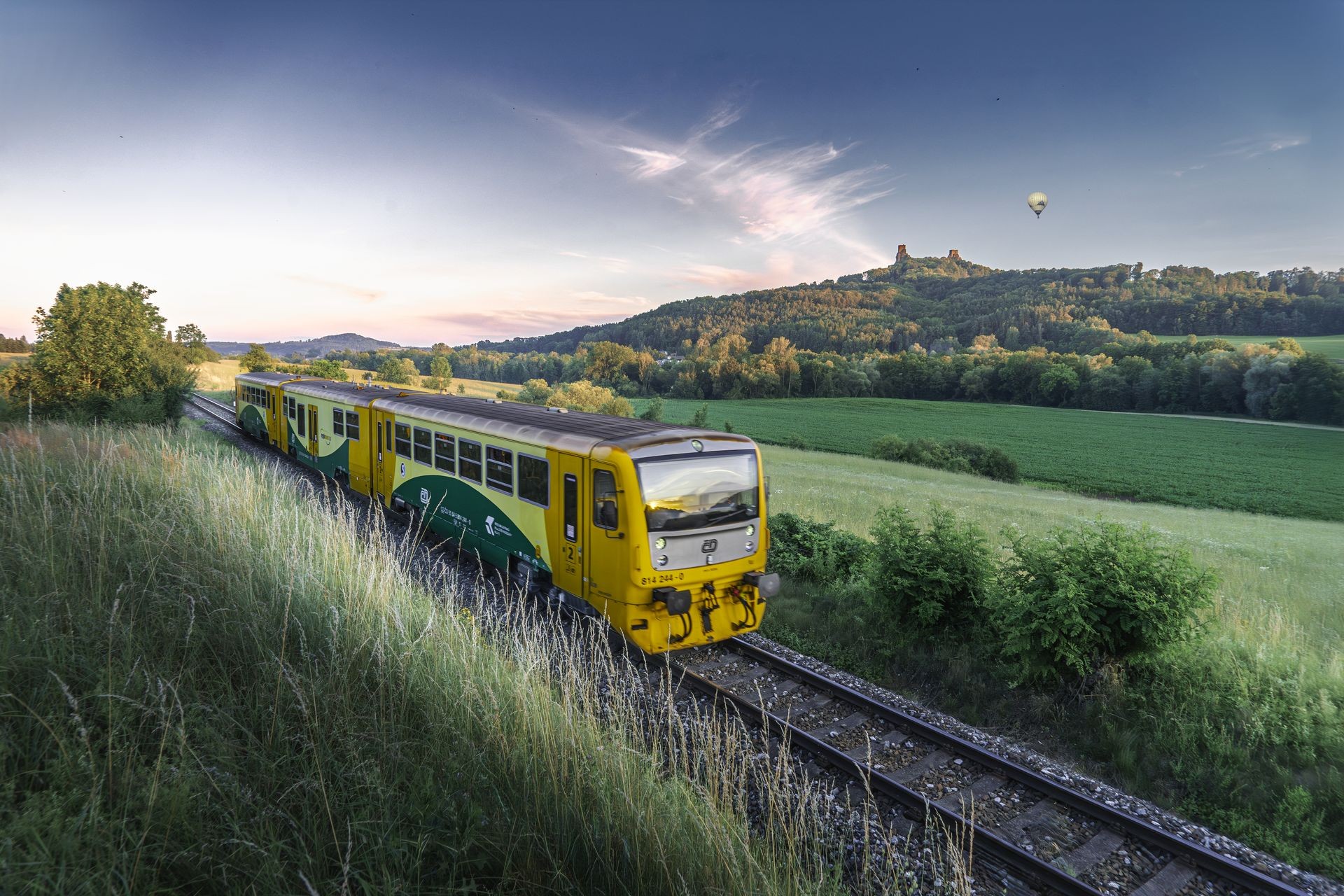 Passenger train travelling through a broad landscape